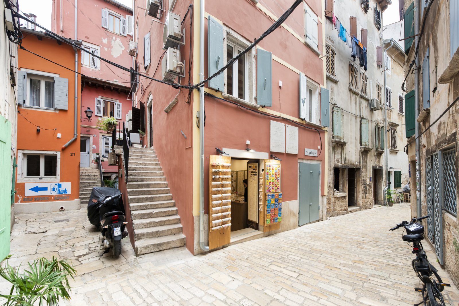 Colourful old town Rovinj street with shops and a scooter