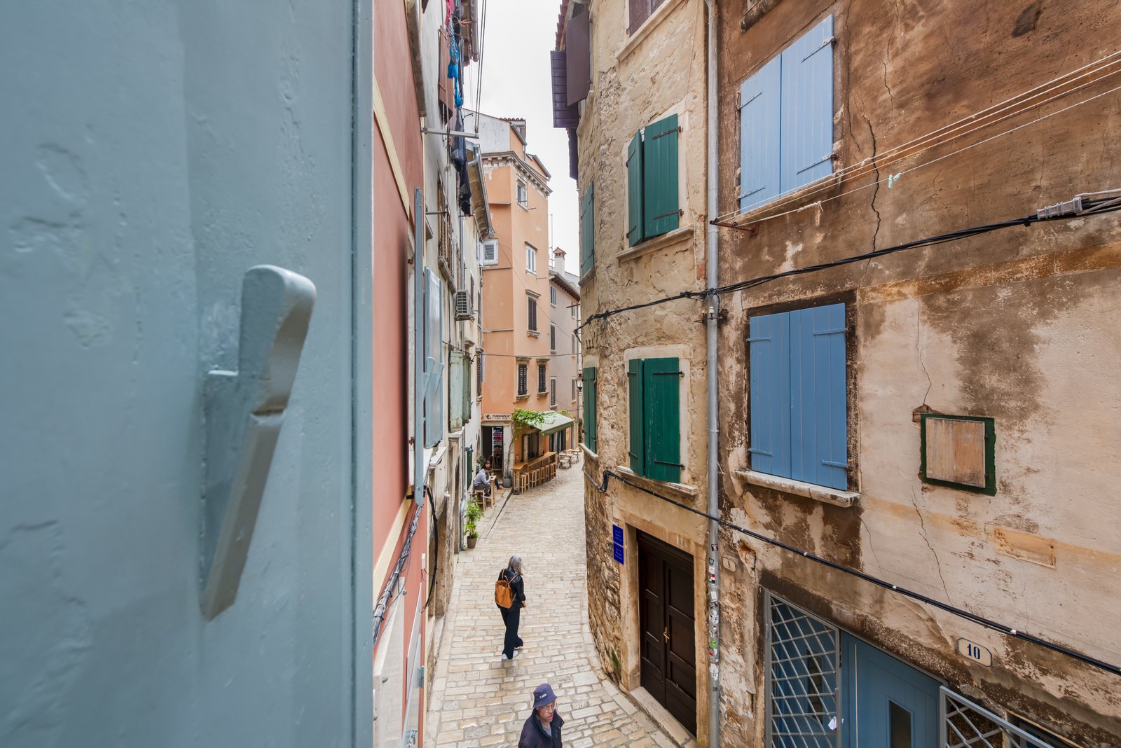 Narrow old town Rovinj alley with green and blue shutters