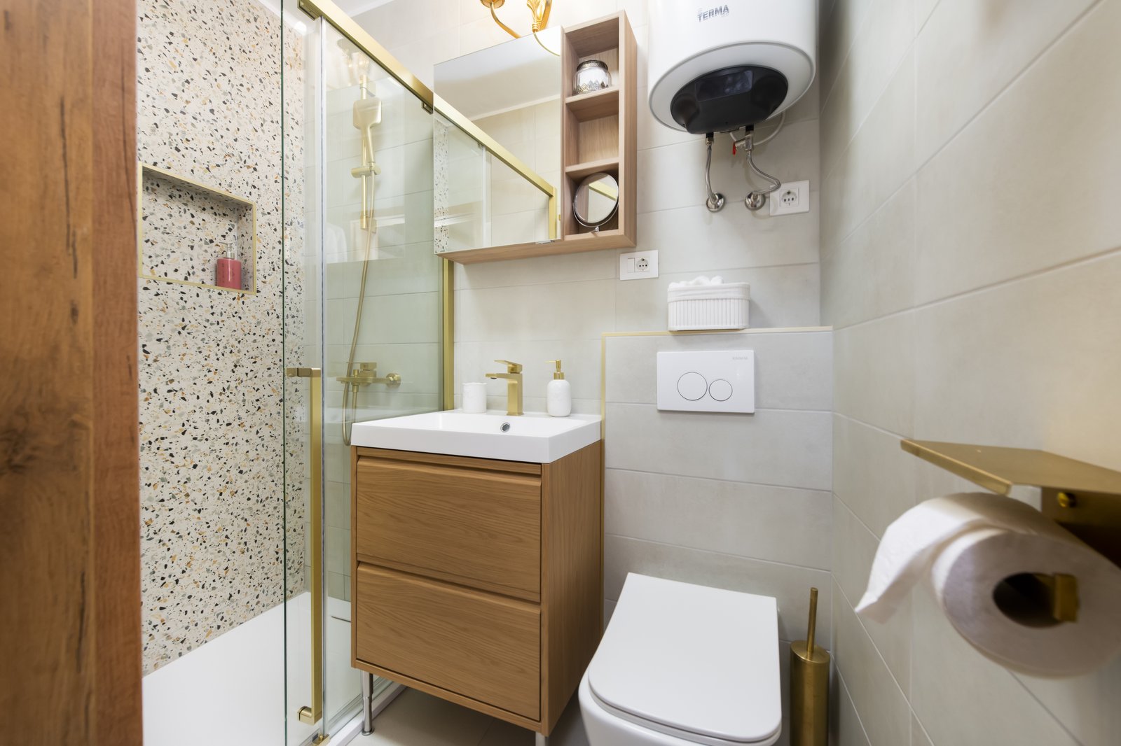 Terrazzo-tiled walk-in shower with brass fittings