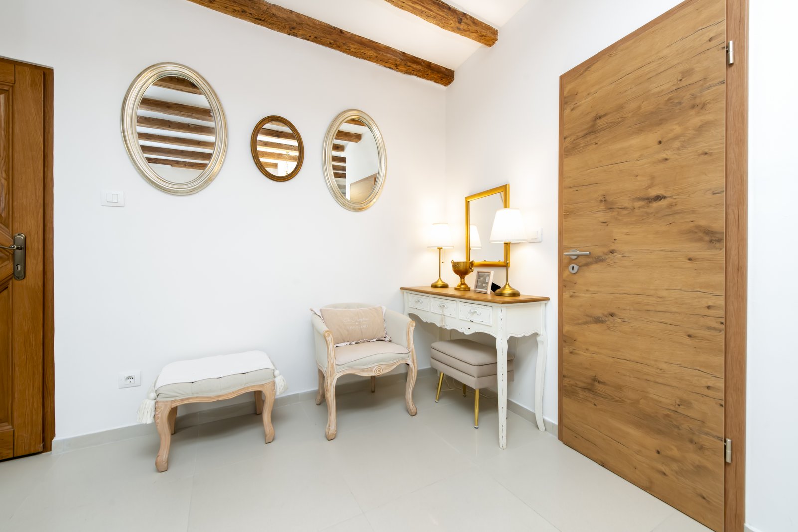 Entrance nook with a gallery of round mirrors and a vintage console table