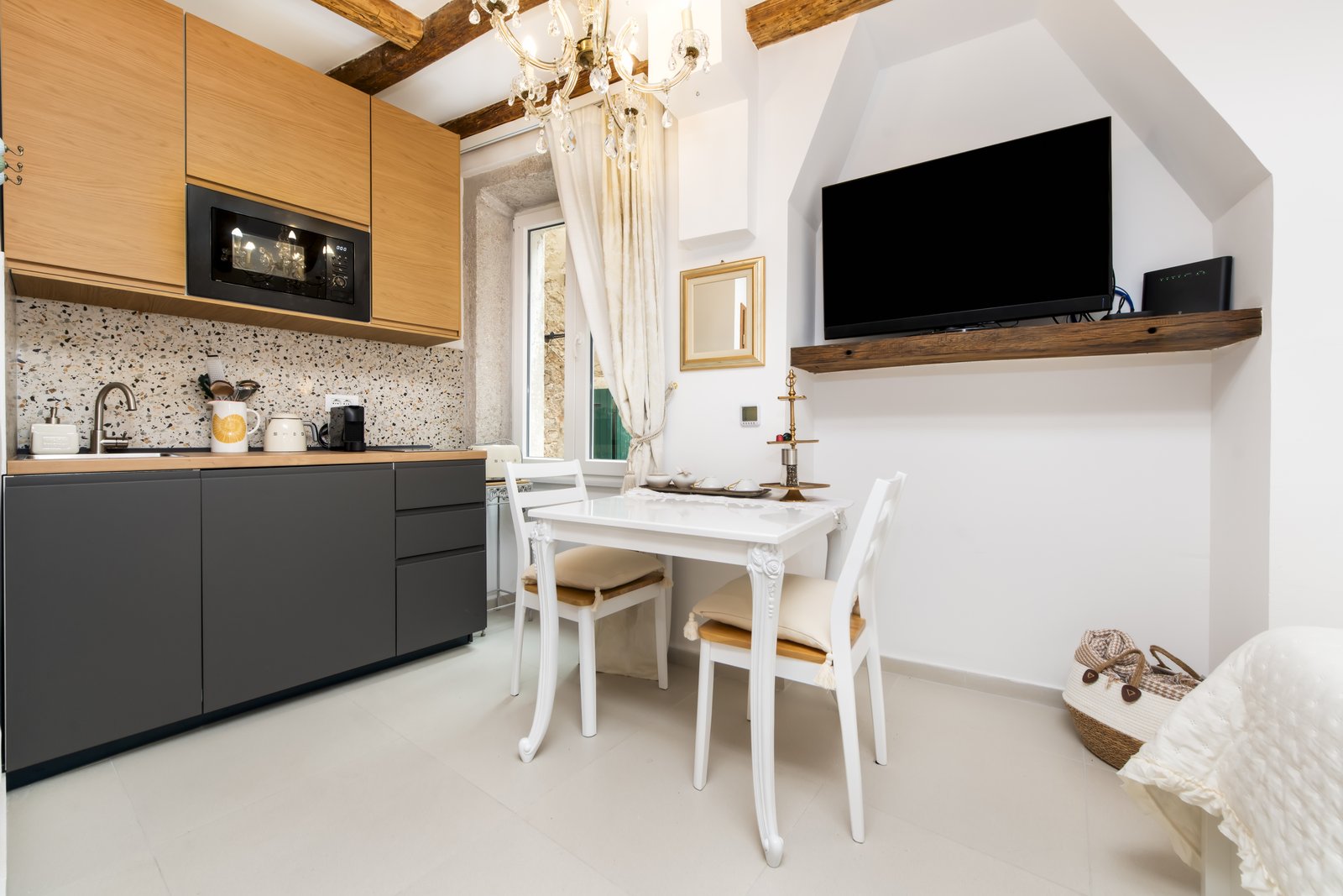 Kitchenette with dark cabinetry and a small white dining table